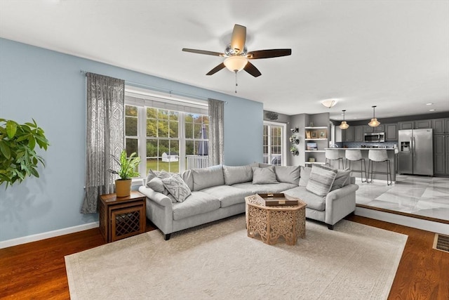 42 Britton St, Raynham, MA 02767 - living area with ceiling fan, light wood finished floors, and baseboards
