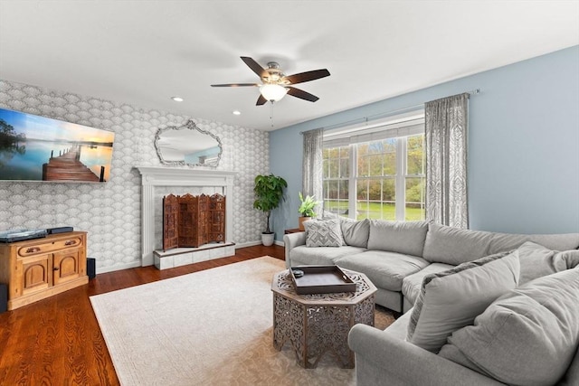 42 Britton St, Raynham, MA 02767 - living room featuring wallpapered walls, a ceiling fan, an accent wall, baseboards, and wood finished floors