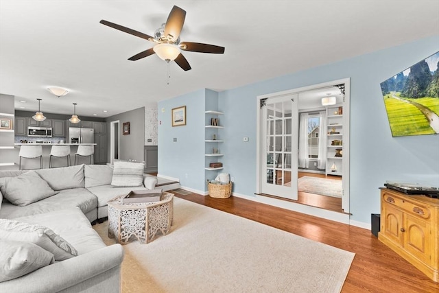 42 Britton St, Raynham, MA 02767 - living room with a ceiling fan, wood finished floors, and baseboards