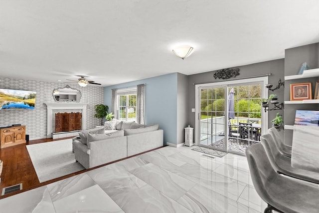 42 Britton St, Raynham, MA 02767 - living area with baseboards, ceiling fan, an accent wall, and a fireplace