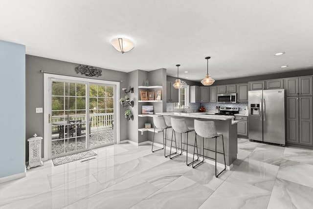 42 Britton St, Raynham, MA 02767 - kitchen with stainless steel appliances, gray cabinetry, a kitchen breakfast bar, light countertops, and a peninsula