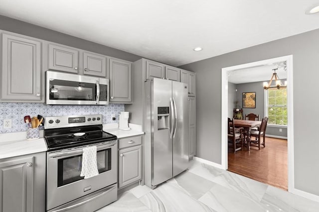 42 Britton St, Raynham, MA 02767 - kitchen with appliances with stainless steel finishes, gray cabinetry, a chandelier, light marble finish floors, and recessed lighting