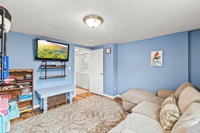 42 Britton St, Raynham, MA 02767 - living area with washer and dryer, wood finished floors, and baseboards