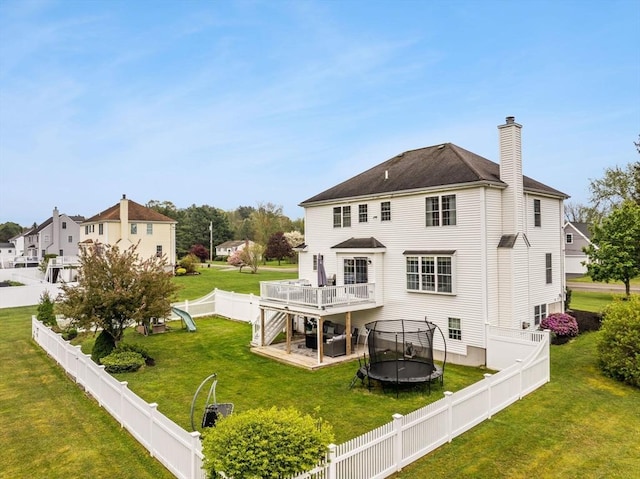 42 Britton St, Raynham, MA 02767 - back of house featuring a chimney, a deck, a trampoline, and stairway