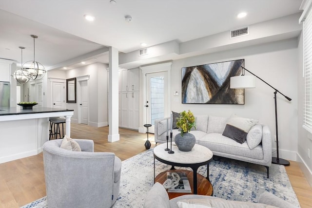 living room with baseboards, light wood-style flooring, recessed lighting, and healthy amount of natural light