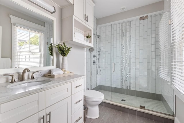 bathroom featuring a stall shower, toilet, and vanity