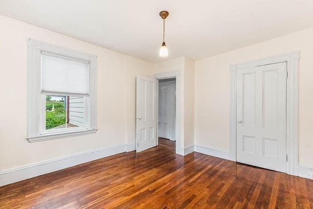 unfurnished bedroom featuring dark wood-type flooring and baseboards