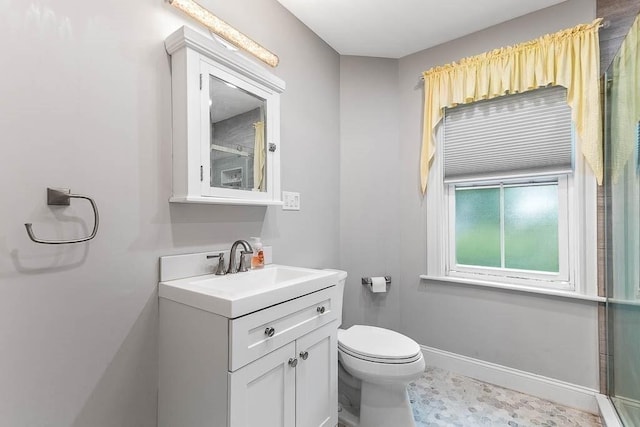 bathroom featuring vanity, toilet, baseboards, and a shower