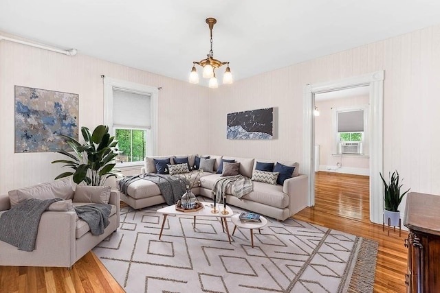 living room with wood finished floors, cooling unit, and a chandelier