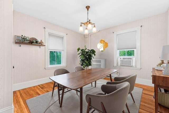 dining room featuring wood finished floors, a chandelier, and baseboards
