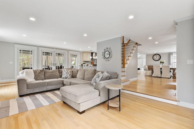living area with baseboards, recessed lighting, light wood-style flooring, and stairway