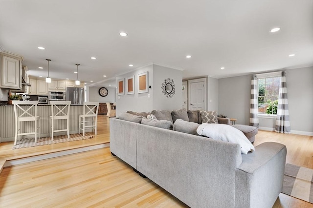 living room with recessed lighting, baseboards, and light wood-style floors