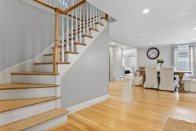 staircase with recessed lighting, baseboards, and wood finished floors