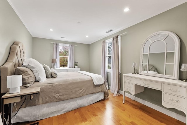 bedroom with visible vents, ornamental molding, light wood finished floors, and recessed lighting