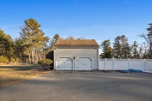 detached garage featuring fence