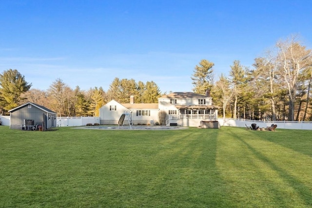 back of property with a lawn and a fenced backyard