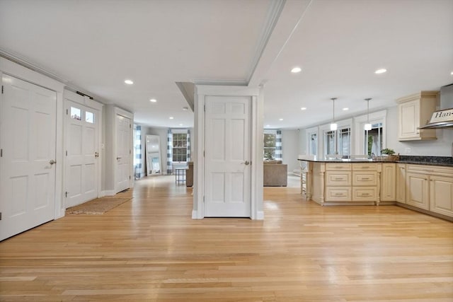 kitchen featuring a peninsula, dark countertops, a breakfast bar area, light wood-type flooring, and recessed lighting
