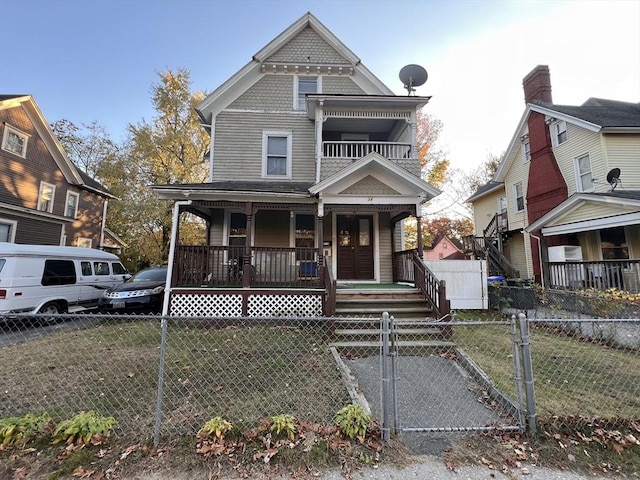 view of front of home featuring a gate, a front lawn, a fenced front yard, and covered porch
