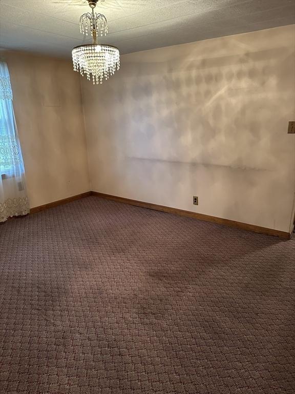 50 Keene St, Lowell, MA 01852 - empty room featuring dark colored carpet and a chandelier