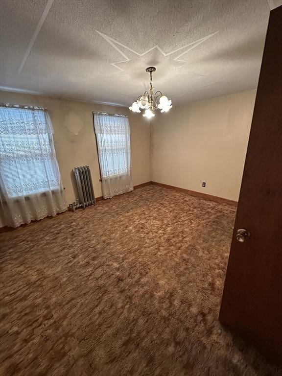 50 Keene St, Lowell, MA 01852 - unfurnished room with a chandelier, radiator, a textured ceiling, and dark carpet