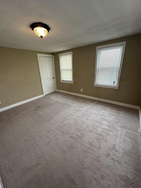 50 Keene St, Lowell, MA 01852 - spare room featuring baseboards and carpet floors