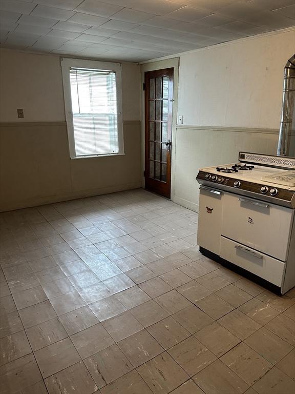 50 Keene St, Lowell, MA 01852 - kitchen featuring white gas range oven and white cabinetry