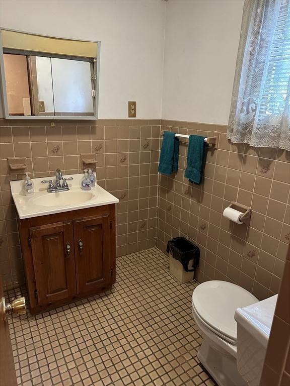 50 Keene St, Lowell, MA 01852 - bathroom with vanity, tile walls, and a wainscoted wall