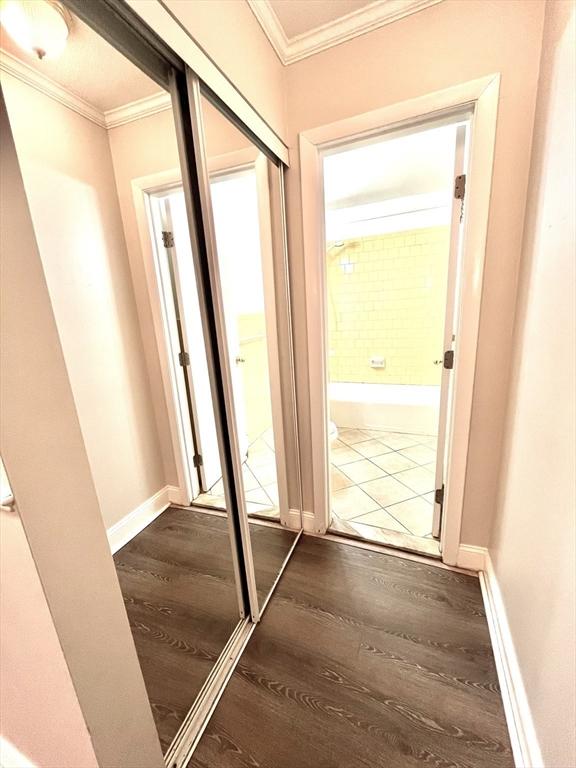 entryway with wood-type flooring and ornamental molding