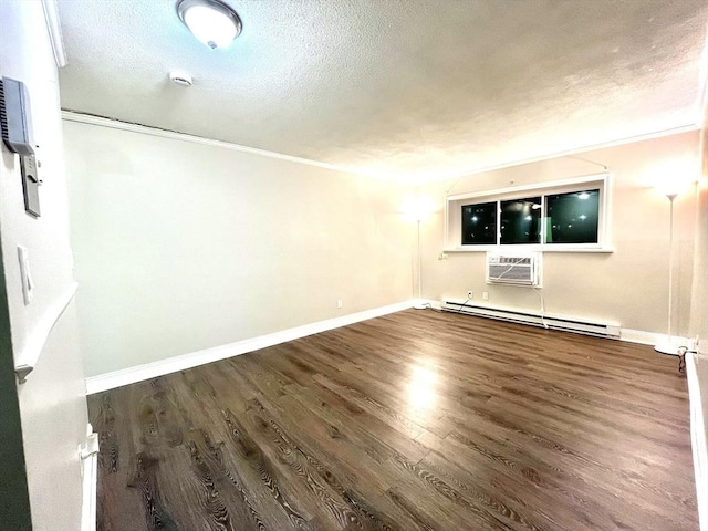 empty room with a textured ceiling, dark hardwood / wood-style flooring, a baseboard radiator, and a wall unit AC