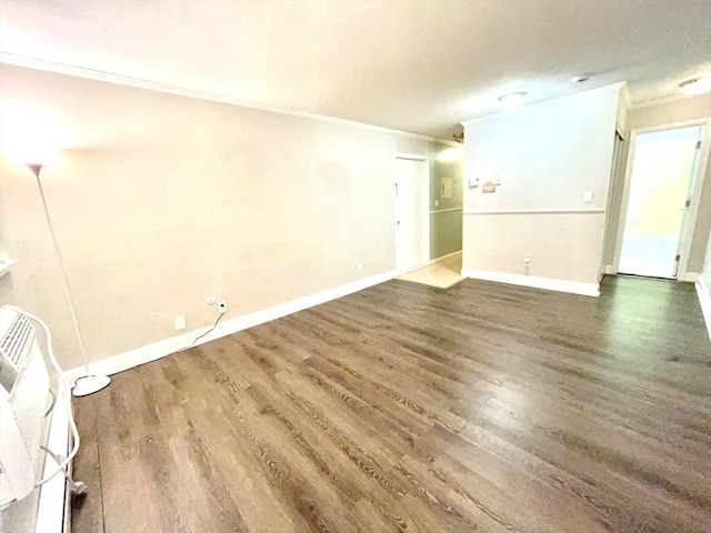 empty room with dark hardwood / wood-style flooring and crown molding