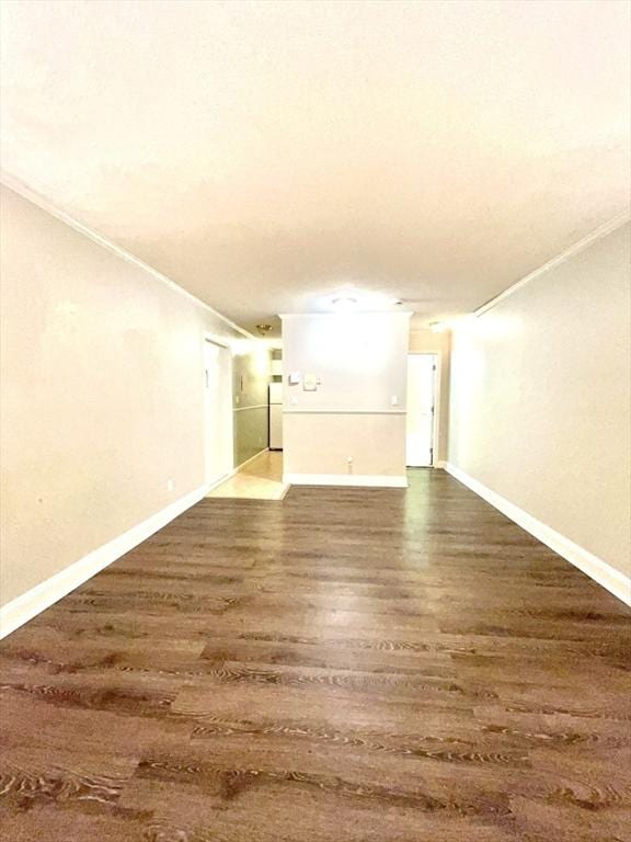 unfurnished living room with dark wood-type flooring and ornamental molding