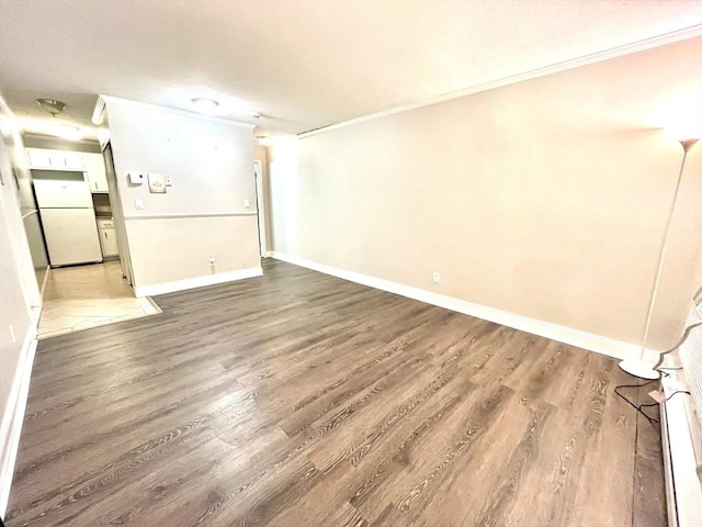 empty room featuring wood-type flooring and crown molding