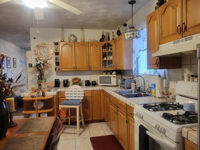 kitchen featuring pendant lighting, white appliances, tile countertops, and sink