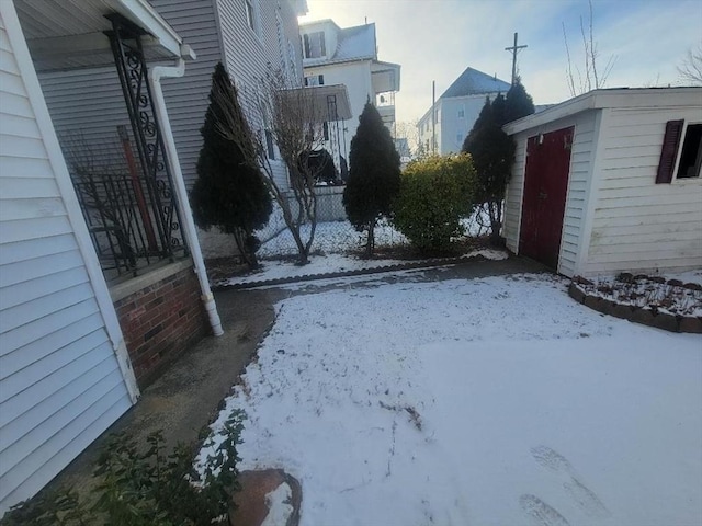 snowy yard with a storage unit