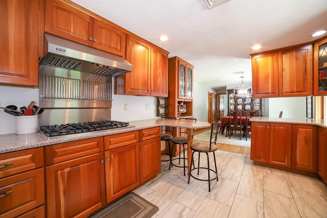 40 Old Stage Rd, Chelmsford, MA 01824 - kitchen featuring under cabinet range hood, glass insert cabinets, light stone counters, recessed lighting, and stainless steel gas cooktop