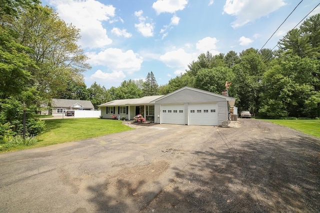 40 Old Stage Rd, Chelmsford, MA 01824 - ranch-style home featuring asphalt driveway, an attached garage, a front lawn, view of wooded area, and a chimney