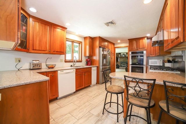 40 Old Stage Rd, Chelmsford, MA 01824 - kitchen with appliances with stainless steel finishes, under cabinet range hood, a sink, a peninsula, and glass insert cabinets