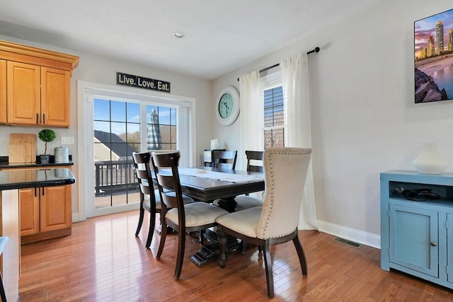 dining area with baseboards, visible vents, and light wood-style floors