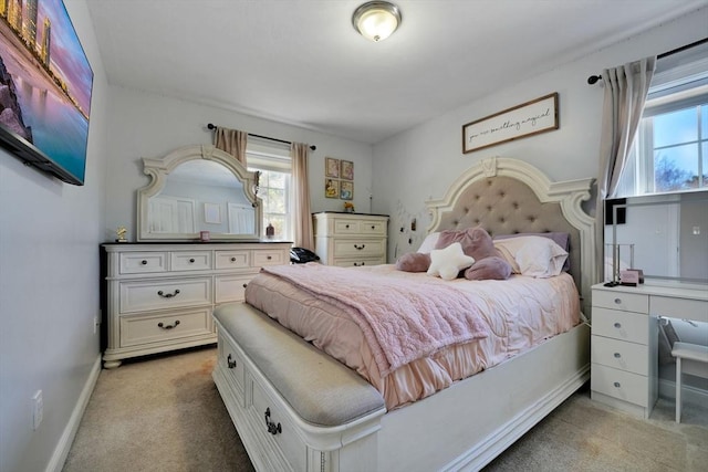 bedroom featuring light colored carpet and baseboards