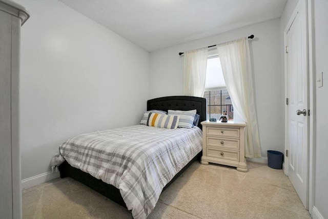 bedroom with baseboards and light colored carpet