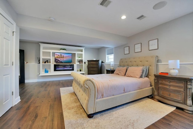 bedroom with recessed lighting, visible vents, baseboards, and wood finished floors