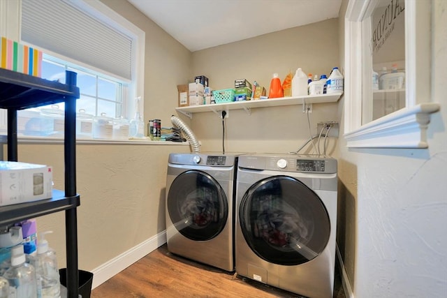 laundry room with laundry area, baseboards, washer and dryer, and wood finished floors