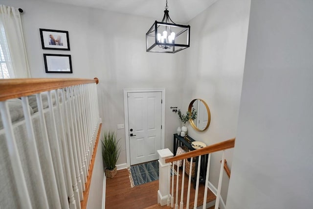 foyer featuring a notable chandelier, baseboards, and wood finished floors