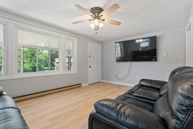 living room featuring baseboards, a ceiling fan, wood finished floors, a textured ceiling, and a baseboard heating unit