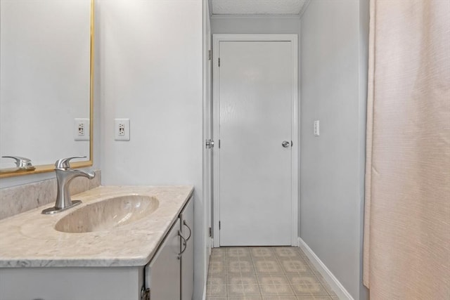 bathroom with tile patterned floors, baseboards, a textured ceiling, and vanity