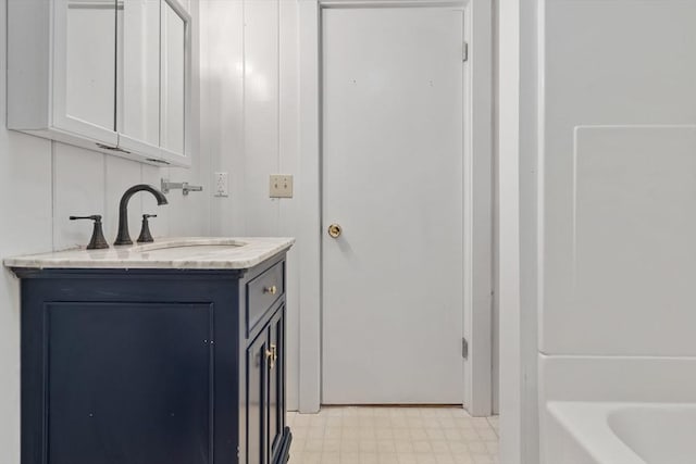 full bath featuring a bathing tub, vanity, and tile patterned floors