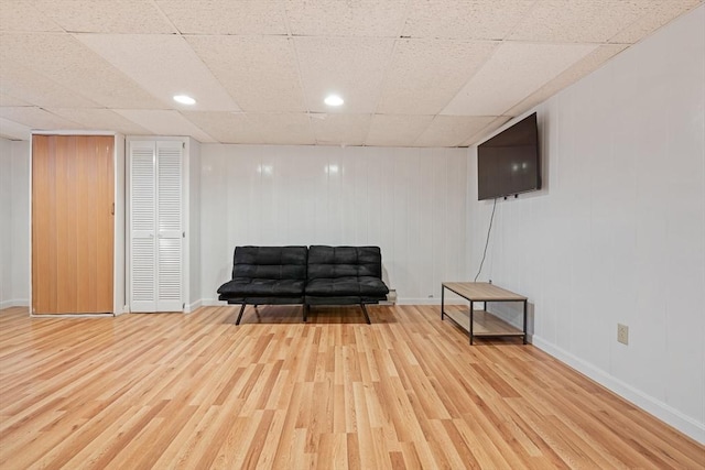 sitting room with a drop ceiling, wood finished floors, and baseboards