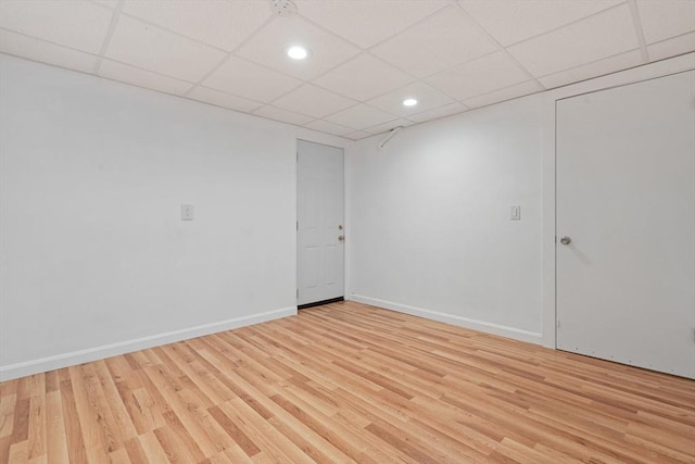 interior space with light wood-type flooring, baseboards, a paneled ceiling, and recessed lighting