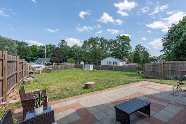 view of yard with a patio area, a fenced backyard, a storage shed, and an outdoor structure