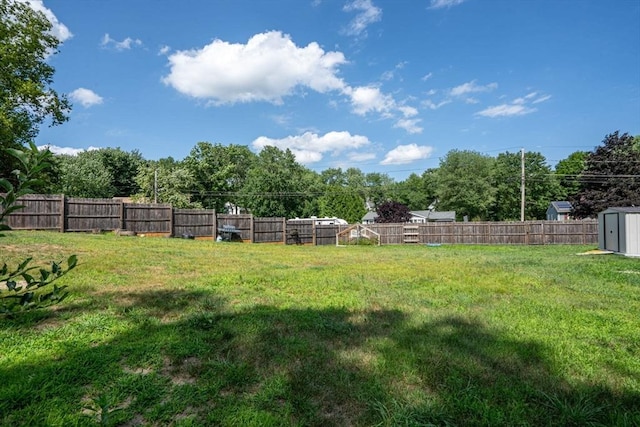 view of yard with a storage unit, an outdoor structure, and a fenced backyard